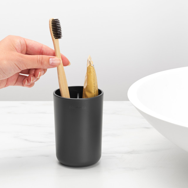 Brabantia ReNew Toothbrush Holder - Dark Grey next to a basin