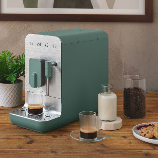 Smeg Bean-To-Cup Automatic Espresso Coffee Machine with Steam Wand - Matt Emerald Green on the table with espresso