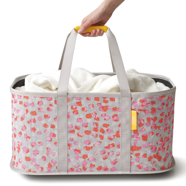 Joseph Joseph Hold-All Peach Collapsible Laundry Basket, 35L held on the handle