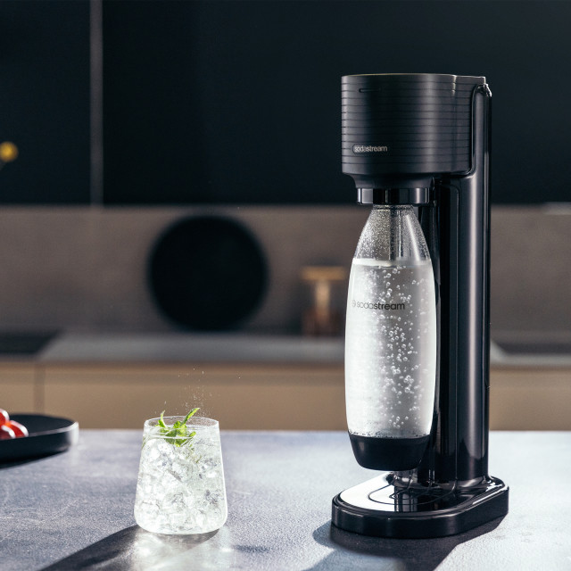 Sodastream Gaia Black Sparkling Water Maker with a glass of sparkling water