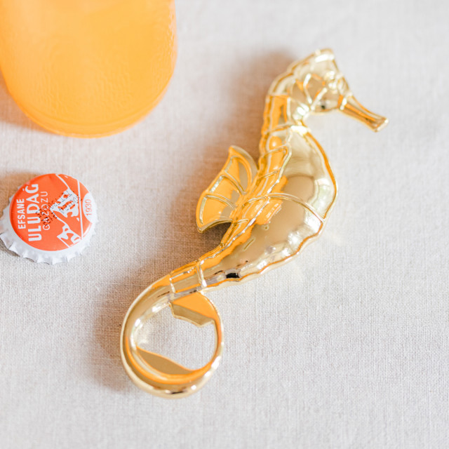 Yvonne Ellen Seahorse Bottle Opener next to a bottle
