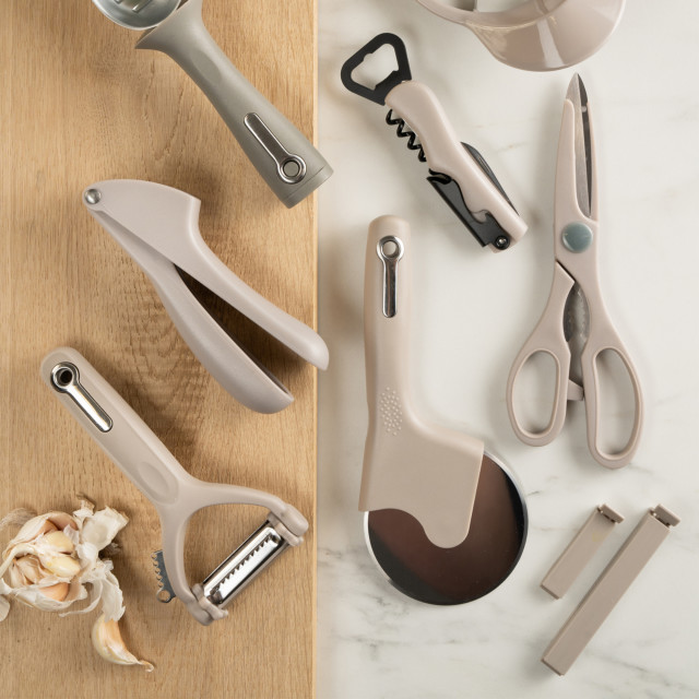 Fusion Twist Multi Peeler - Grey on the table with other kitchen tools