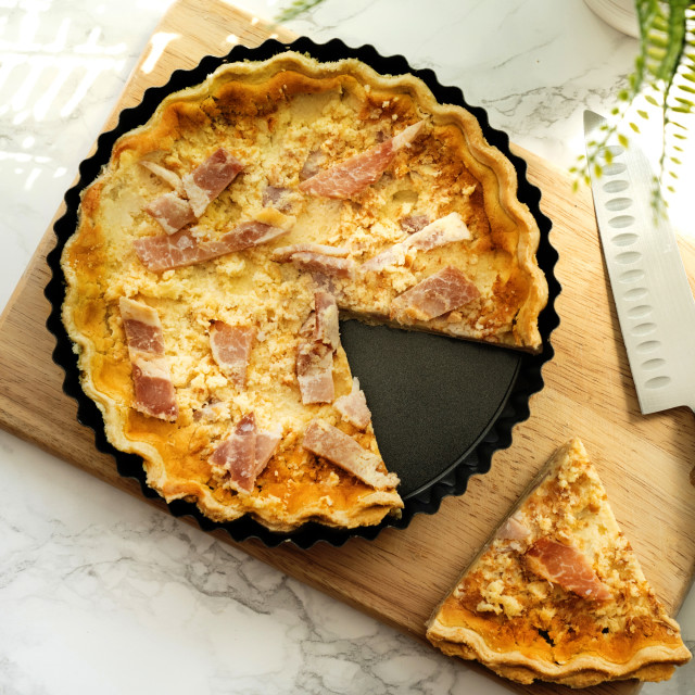 Luxe Kitchen Fluted Loose Base Quiche Pan - 25cm with a slice of pie