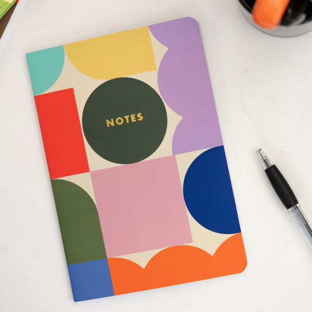 Kikkerland A5 Notebooks, Set of 3 on the table with a pen