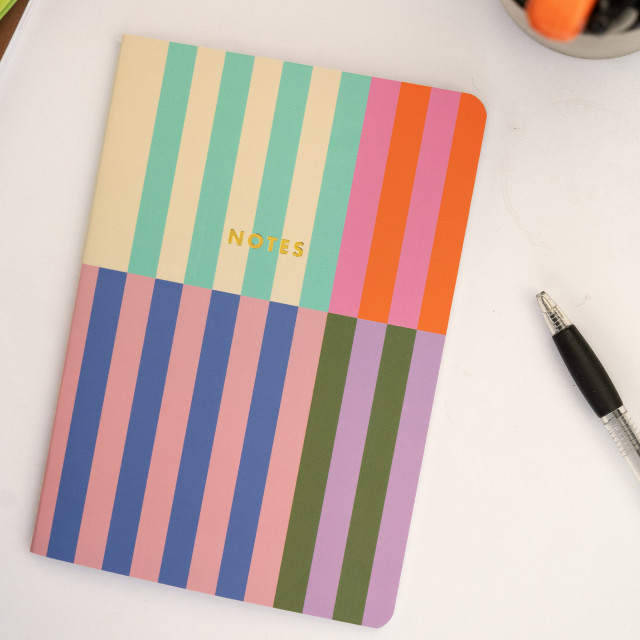 Kikkerland A5 Notebooks, Set of 3 on the table with a pen