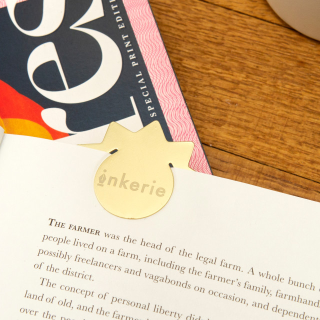 Kikkerland 3-in-1 Metal Paperclips on a page in a book