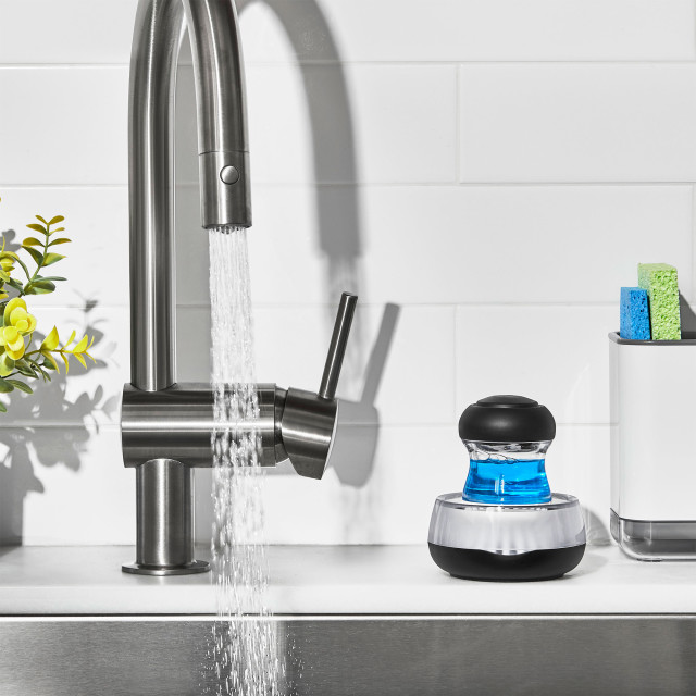 OXO Palm Dispensing Brush with Holder next to a tap