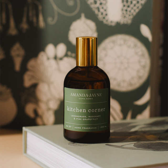 Amanda Jayne Kitchen Corner Lemongrass, Rosemary & Pink Grapefruit Home Fragrance, 100ml showing scale on a book