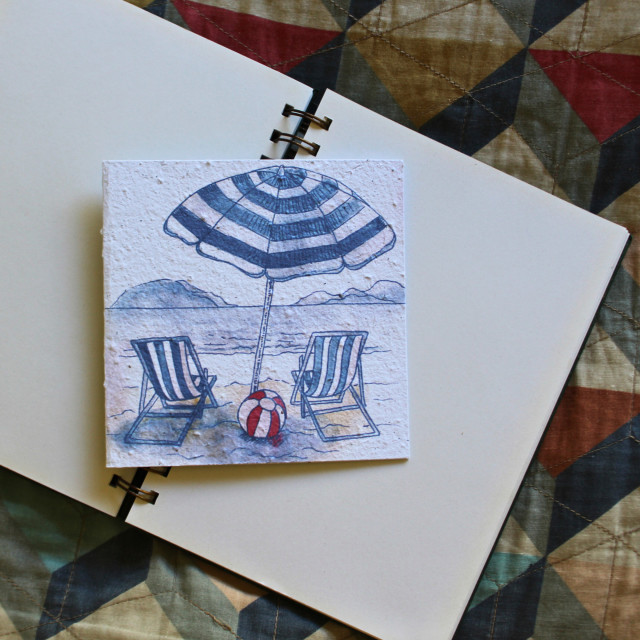 Growing Paper Beach Day Greeting Card showing scale on a book