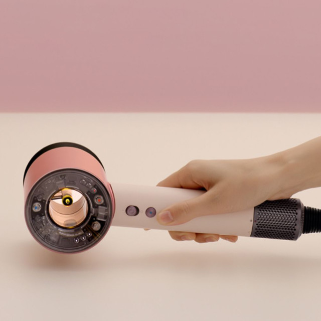 Dyson Supersonic Nural Hair Dryer - Ceramic Pink/Rose Gold handheld showing scale