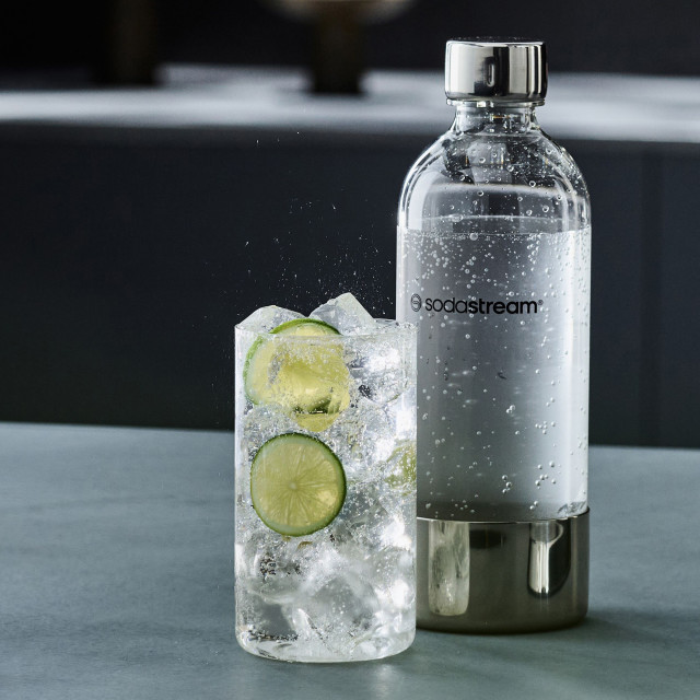 Sodastream Enso Carbonating Bottle, 1L on the kitchen island with a glass of sparkling water