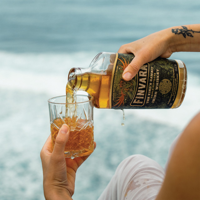 Finvara The Kings Gambit Irish Whiskey, 700ml poured in a glass at the beach