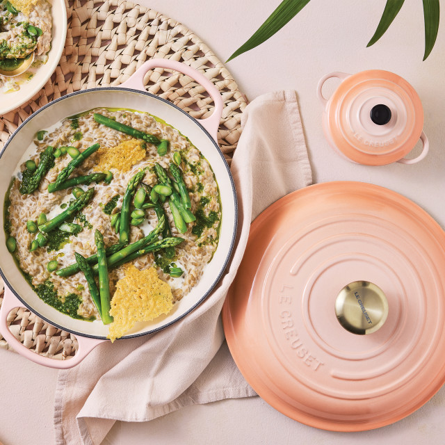 Le Creuset Peche Signature 5.3 Litre Round Cast Iron Casserole, 26cm with food on the table