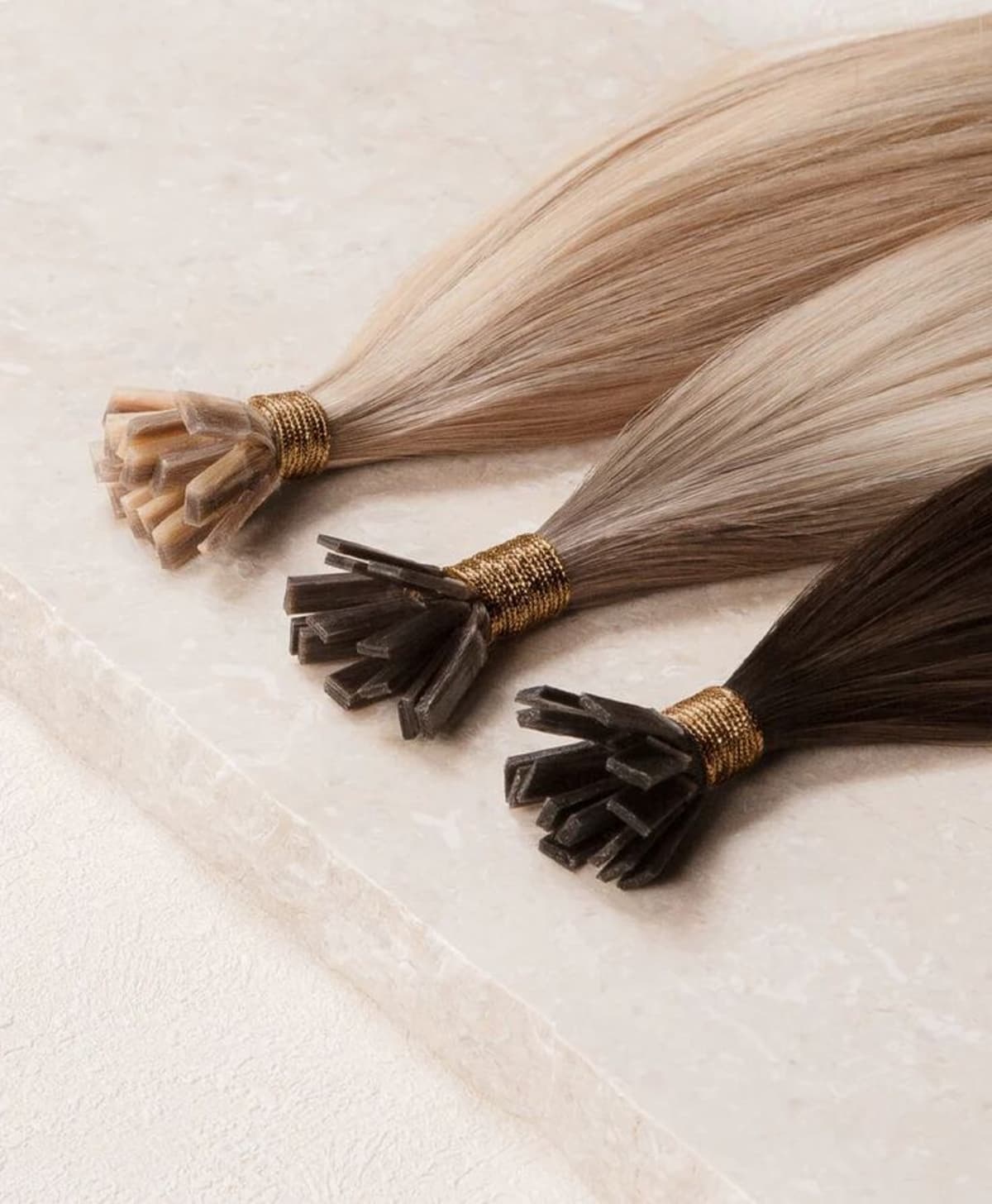 Tre flat tip-slingor med keratinspets och silvertråd mot vit bakgrund