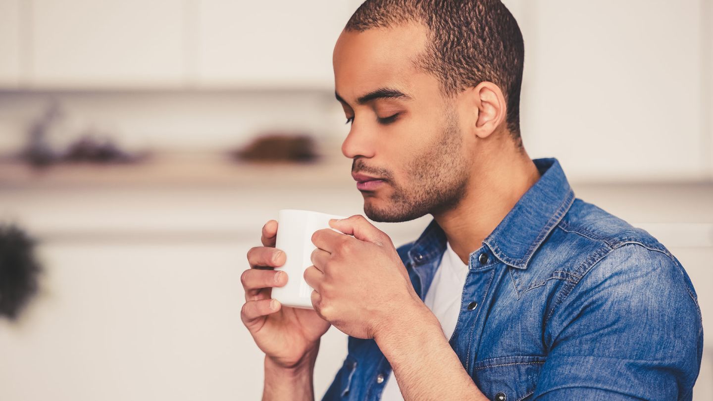 Man leaning over a mug of tea wondering if there are natural cures for erectile dysfunction