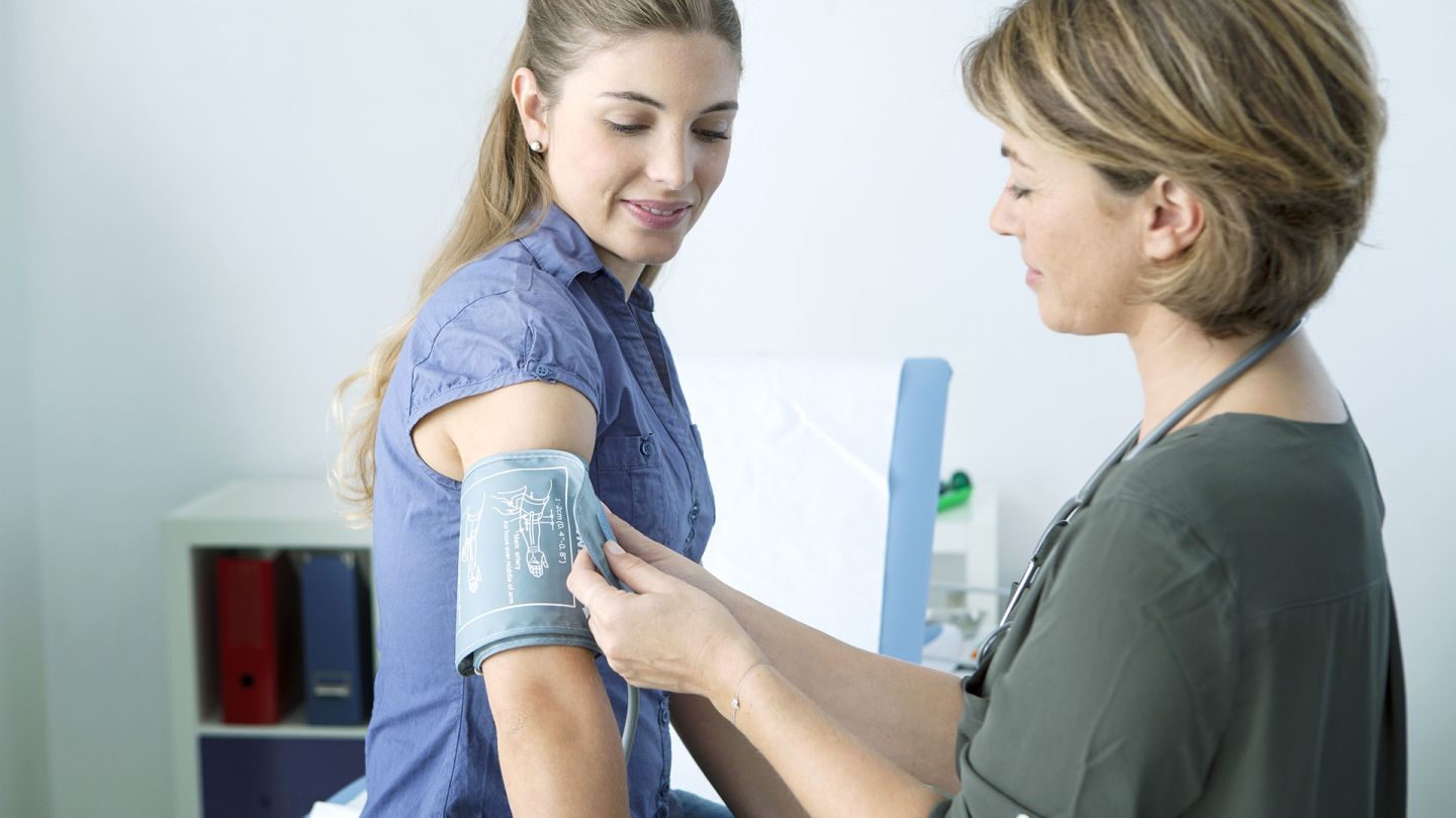 Woman who takes the contraceptive pill having her blood pressure checked by a doctor
