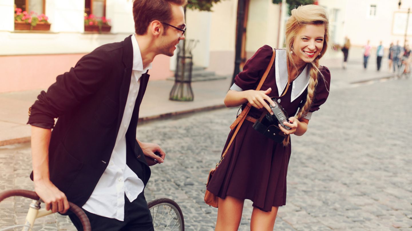 Woman interested in female Viagra holding a camera talking to a man with a bicycle