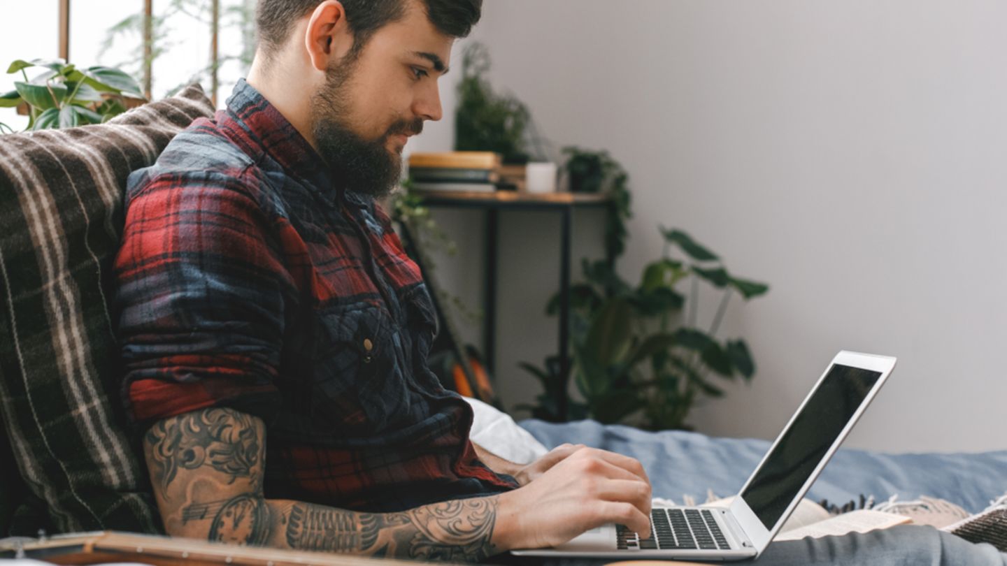 Man sat in bed on his laptop looking for alternatives to Viagra