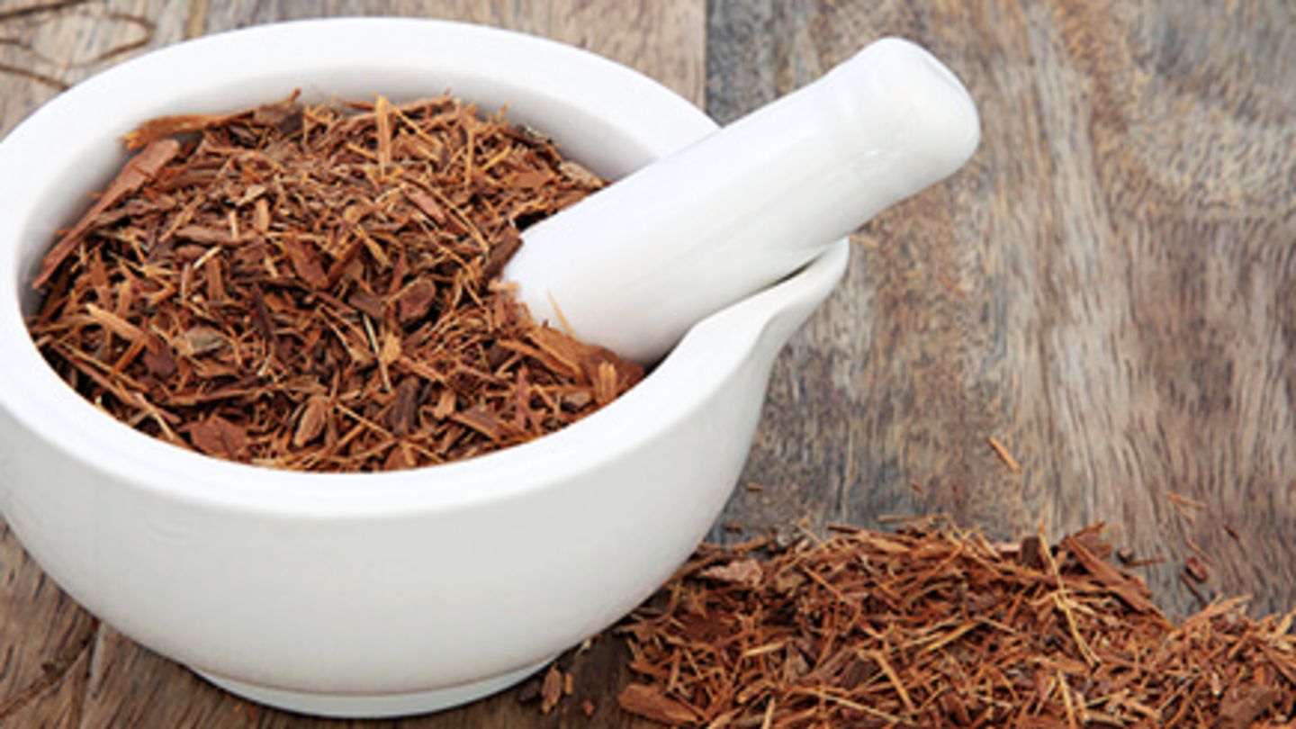 Mortar and pestle on a wooden bench full of yohimbine bark