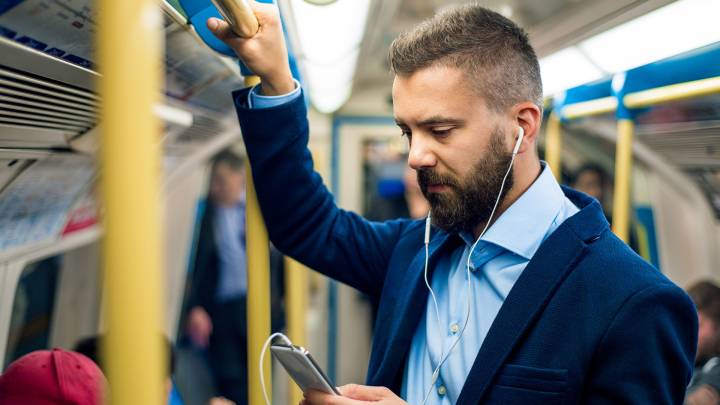 Man on the tube checking how long Viagra lasts on his smartphone