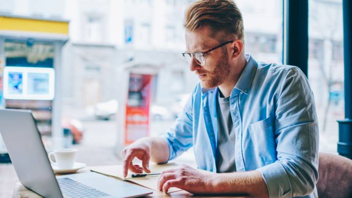 Man in cafe checking his laptop to see if there is a herpes vaccine