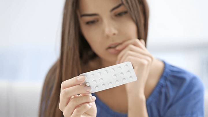 Frau hält den Blister einer Mikropille (Kombinationspille)