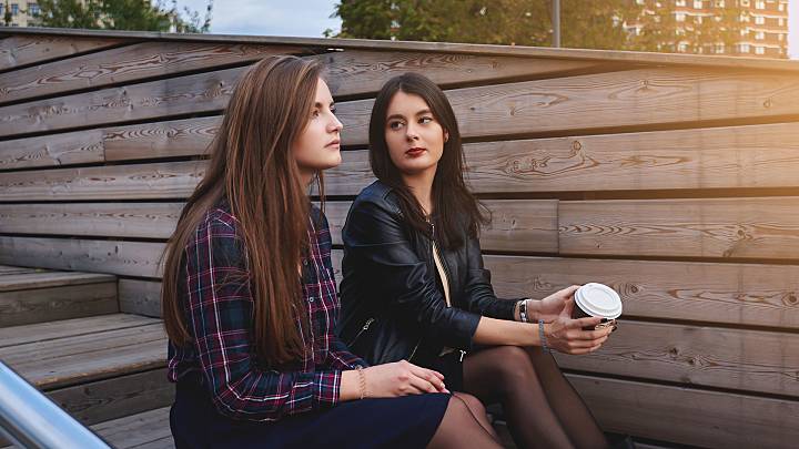 2 woman sat on wooden steps talking about pelvic inflammatory disease