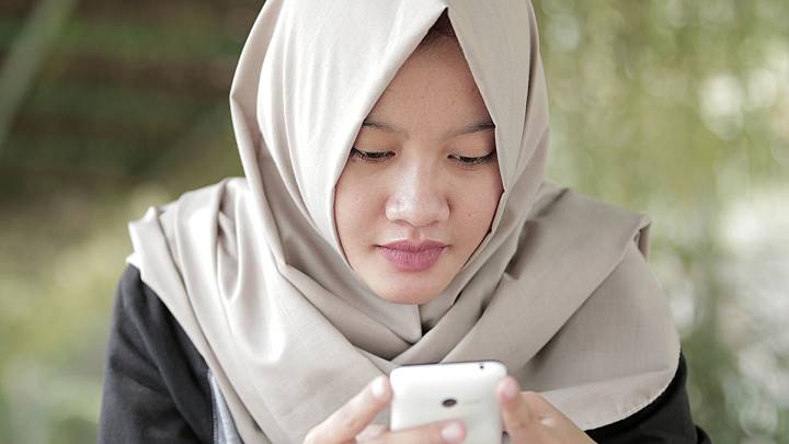Woman in a garden looking up asthma treatment on her phone