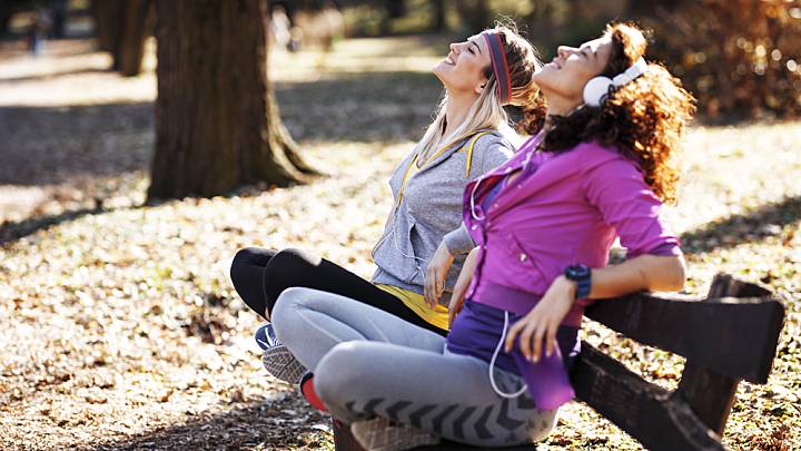 2 women practicing the Buteyko Breathing Method on a park bench after jogging