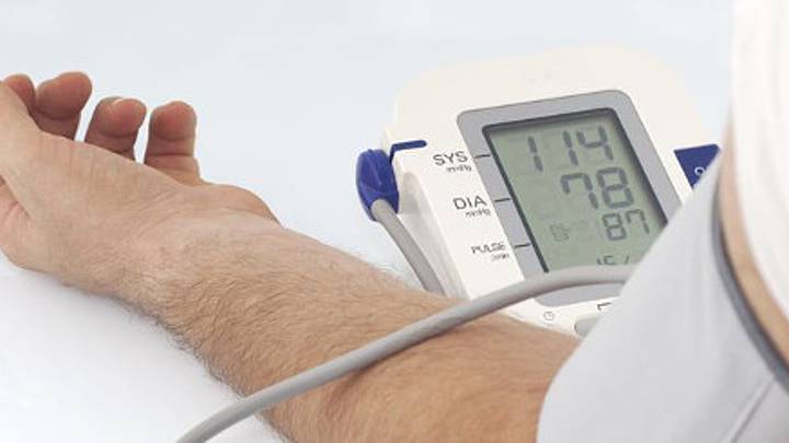 Man with his arm strapped to a monitor that shows high blood pressure is in need of treatment for hypertension