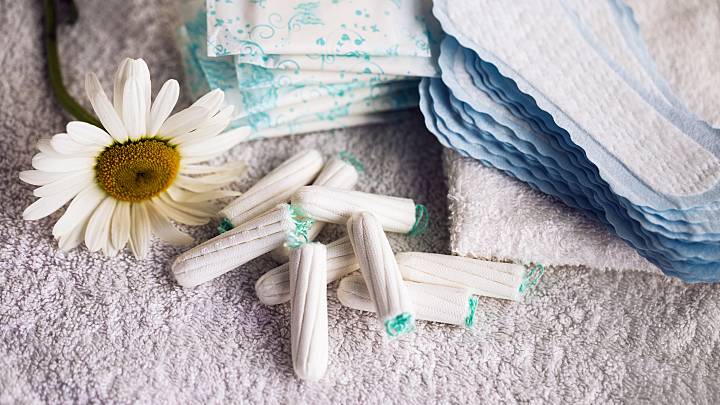 Verschiedene Damenhygieneartikel zur Verwendung während der Menstruation, auch Periode genannt, liegen zusammen auf einem Handtuch.