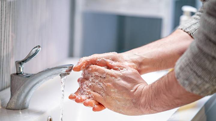 Mann wäscht sich die Hände am Waschbecken