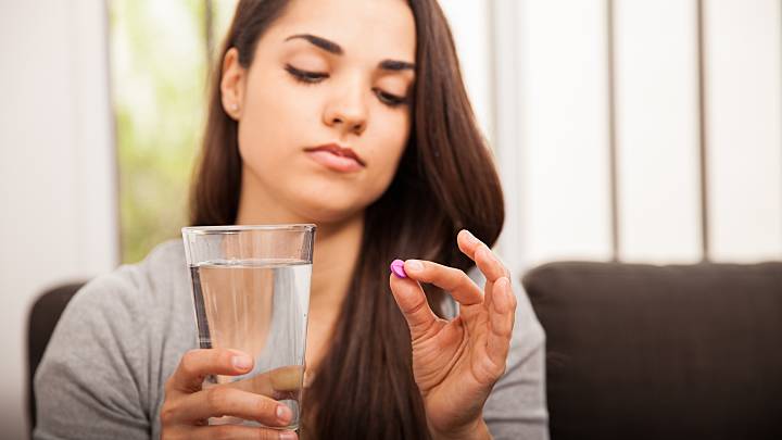 losing weight on the pill holding glass of water and pill