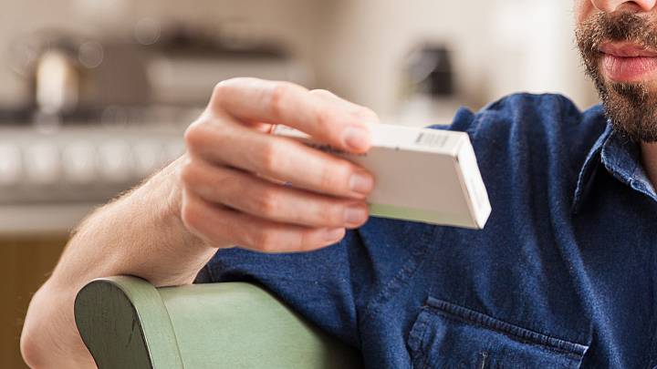 person looking at pill packet