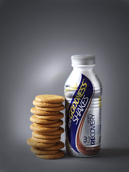 bottle of goodness shakes sports drink next to a stack of 15 ginger nut biscuits