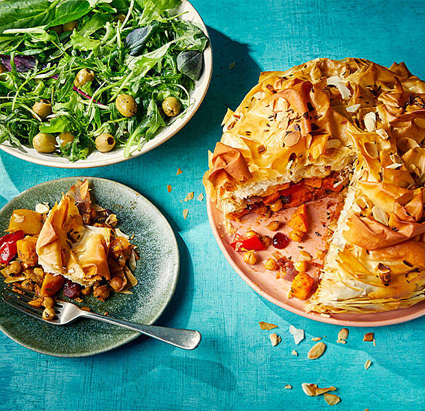 Moroccan-inspired chickpea and apricot vegan filo pie with a small serving on a plate and a side saled