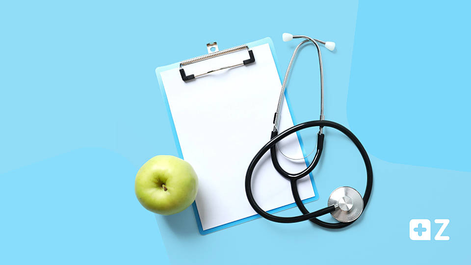 EIn Clipboard mit einem Stethoskop und einem Apfel daneben