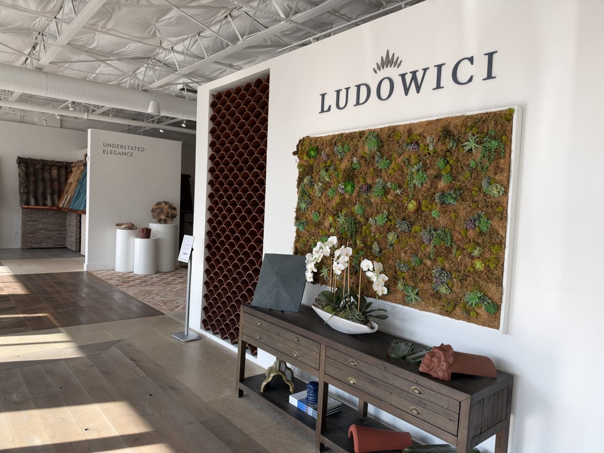 Ludowici showroom with a curved tile alcove, brand wall, and living wall display