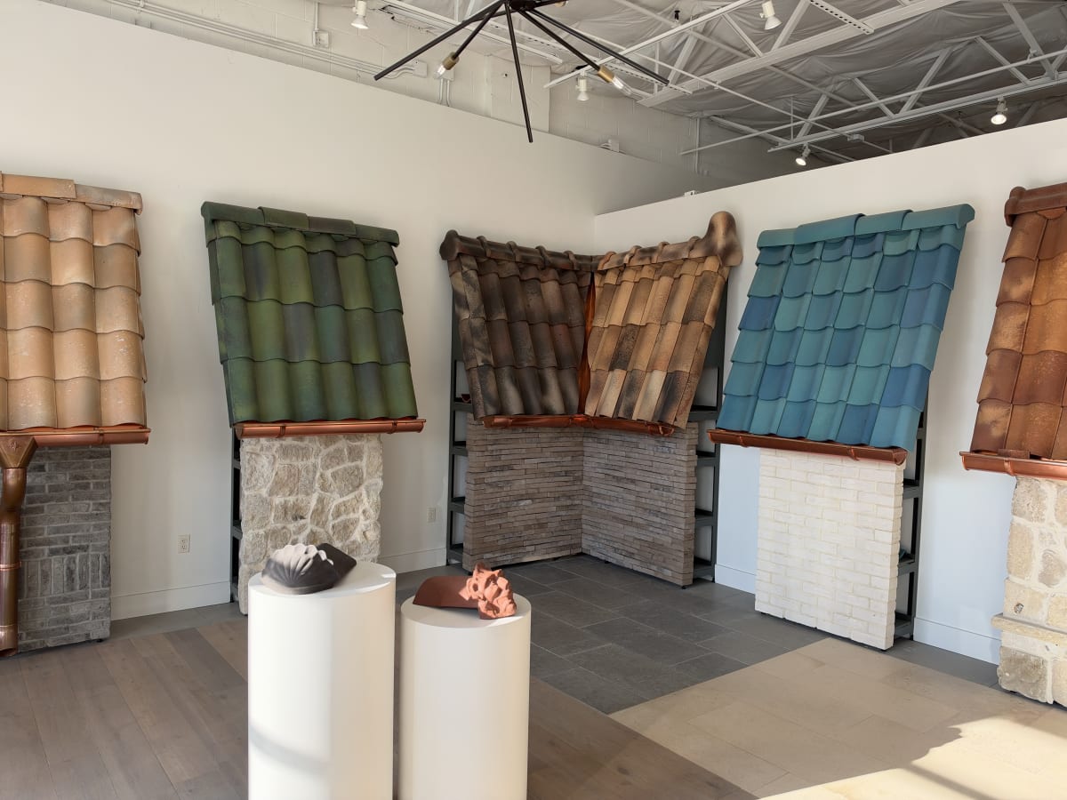 Ludowici showroom display of slate-profile terra cotta tile in sand, green, brown, and teal blends with copper edging