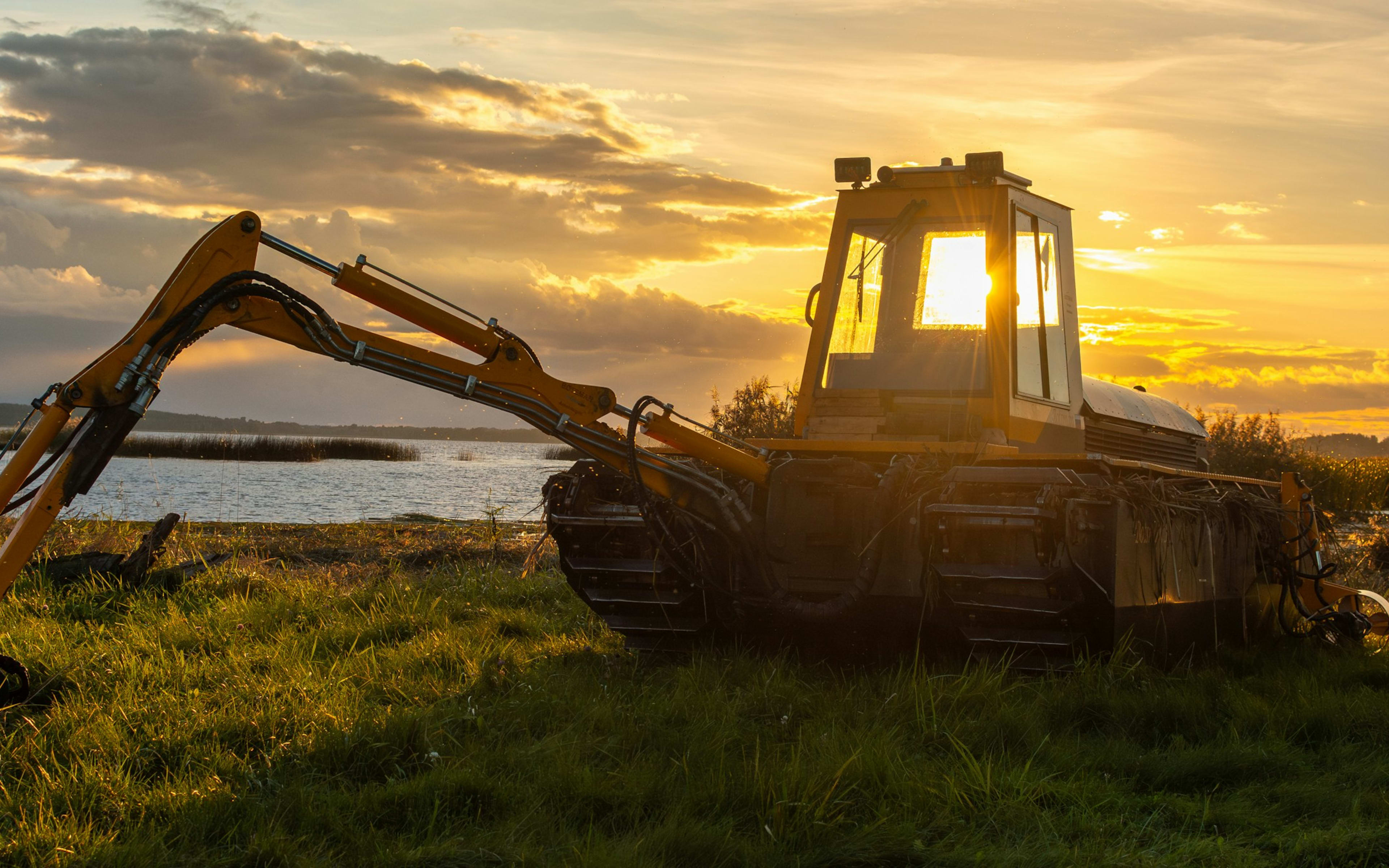 Sample photo of an amphibious excavator on a lakeshore at sunset