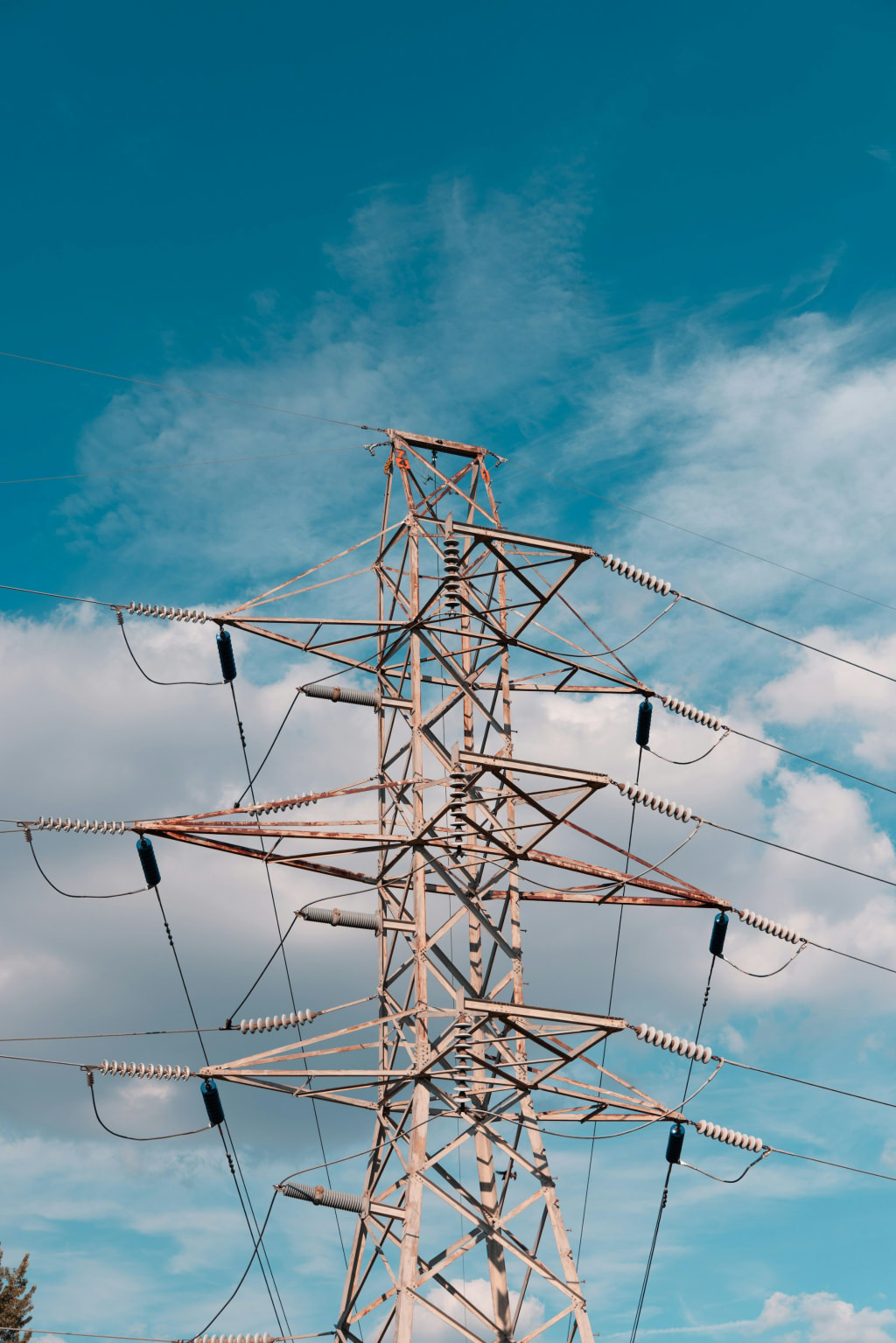 A high-voltage transmission line against a clear blue sky.