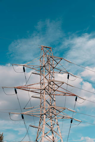 A high-voltage transmission line against a clear blue sky.