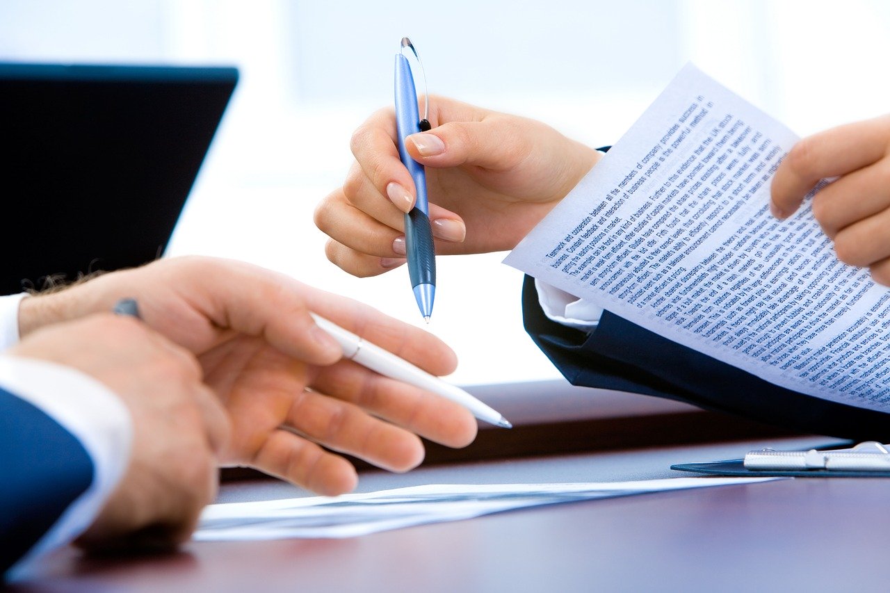Two people sitting at a desk going over documents.