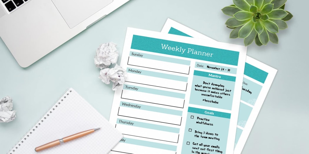 two weekly planner pages next to paper and pencil.