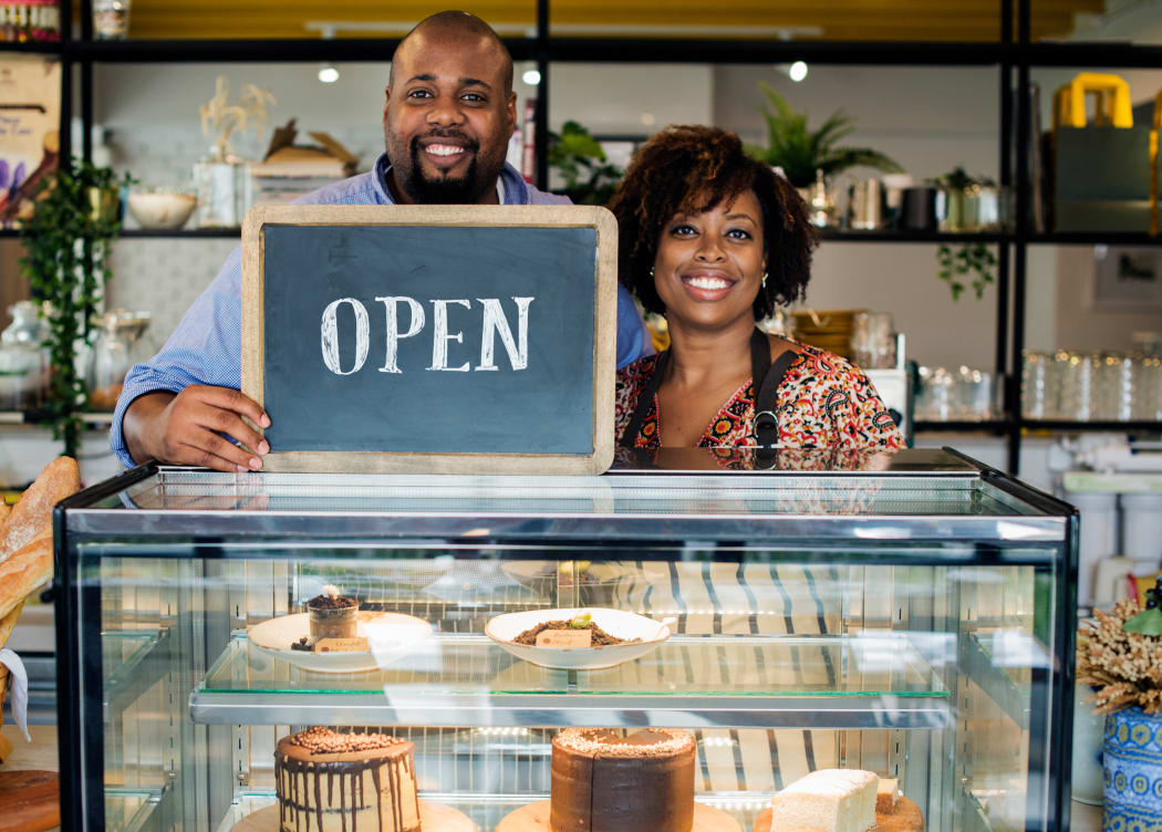 couple behind open sign