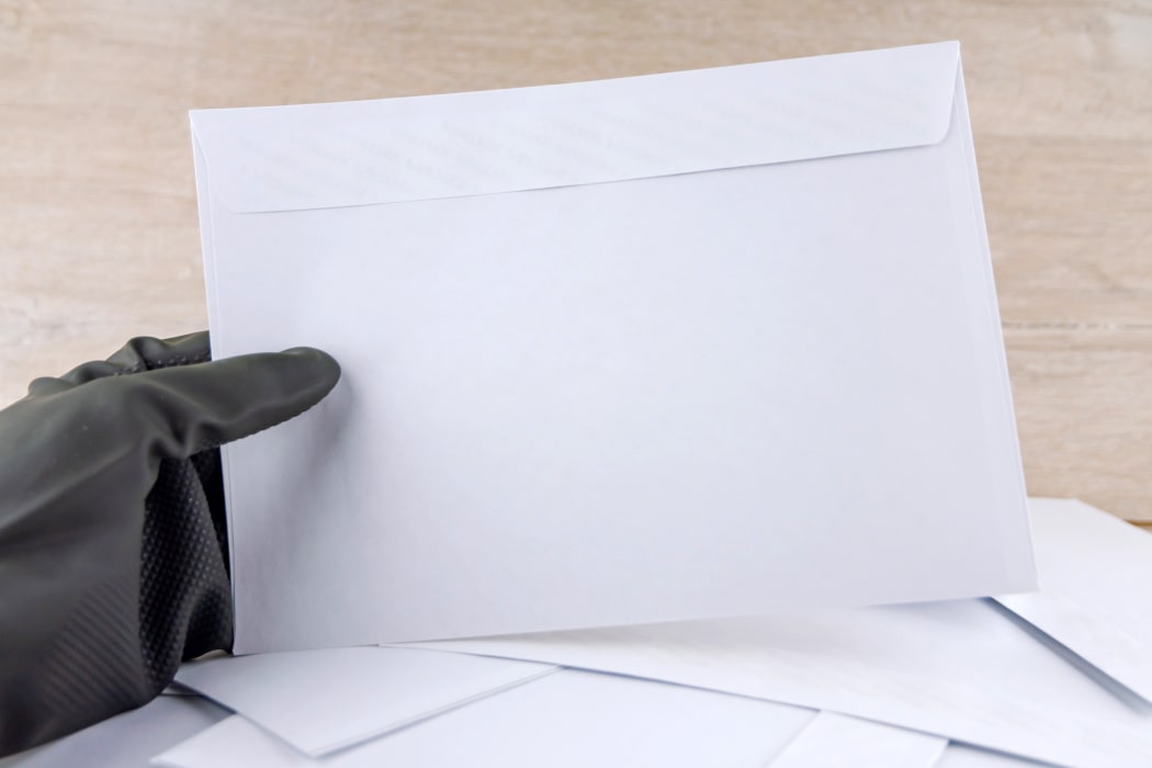 gloved hand on envelope