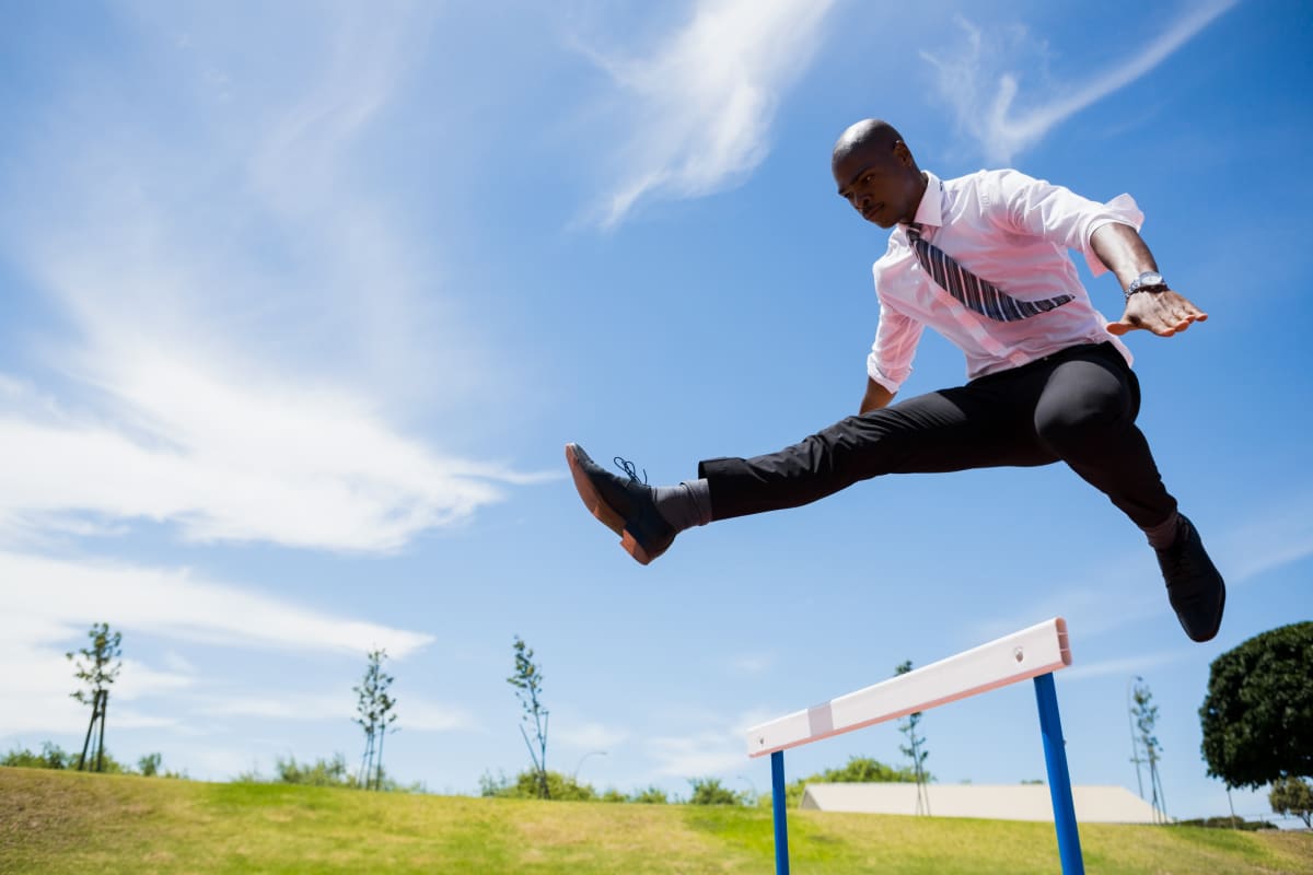 businessman jumping hurdle