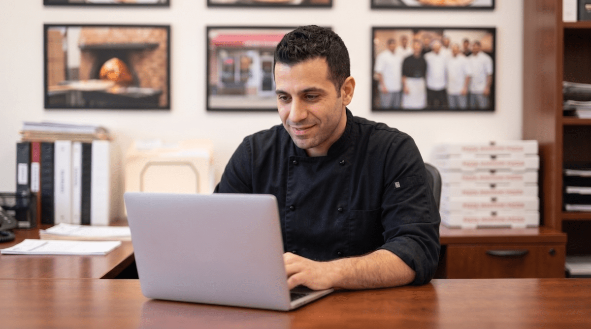 Pizzeria owner registering a pizza restaurant business as an LLC from counter
