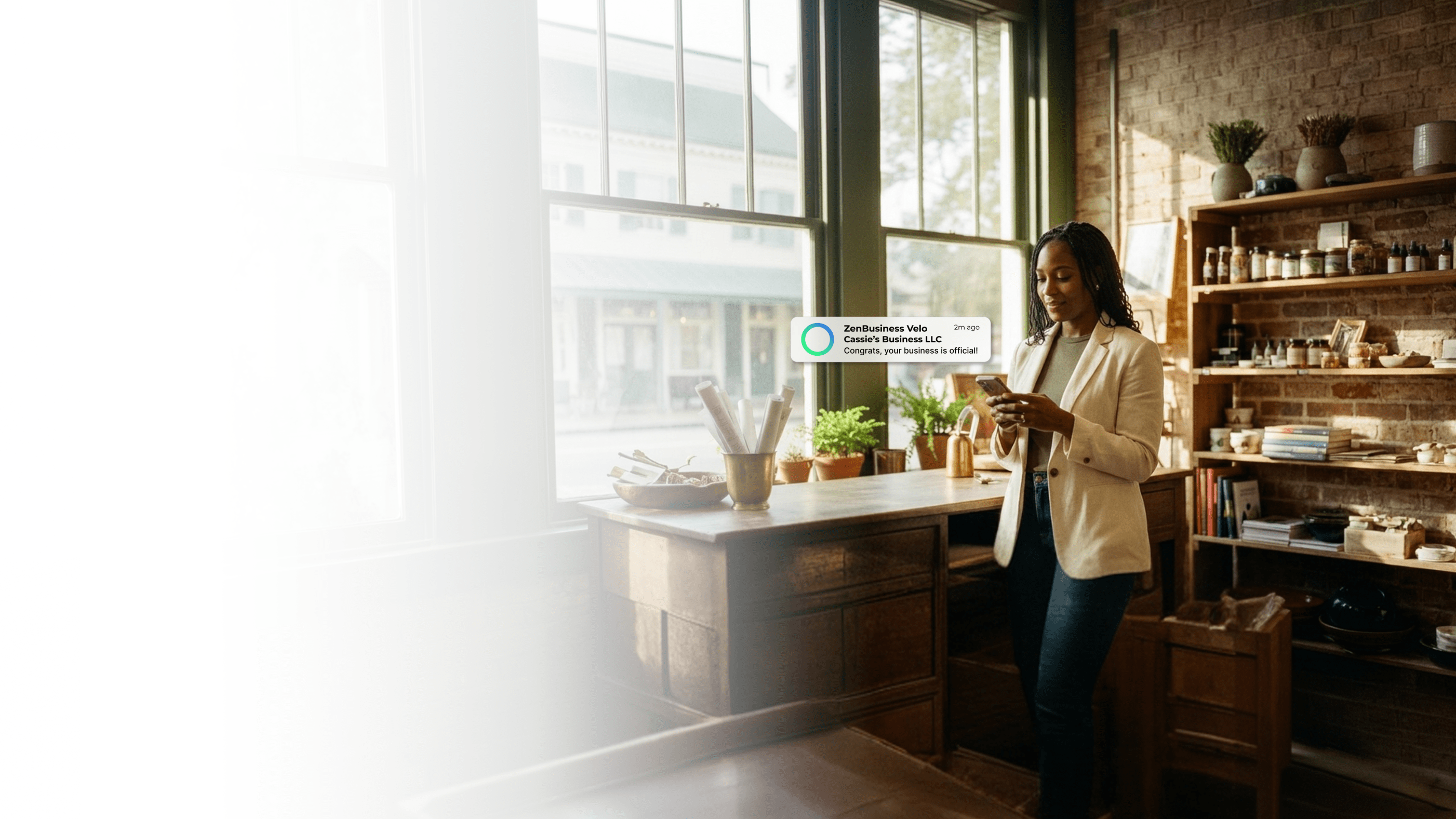Female boutique shop owner inside her Georgia retail store with shelves of handcrafted goods checking her ZenBusiness Velo notification that her LLC is approved