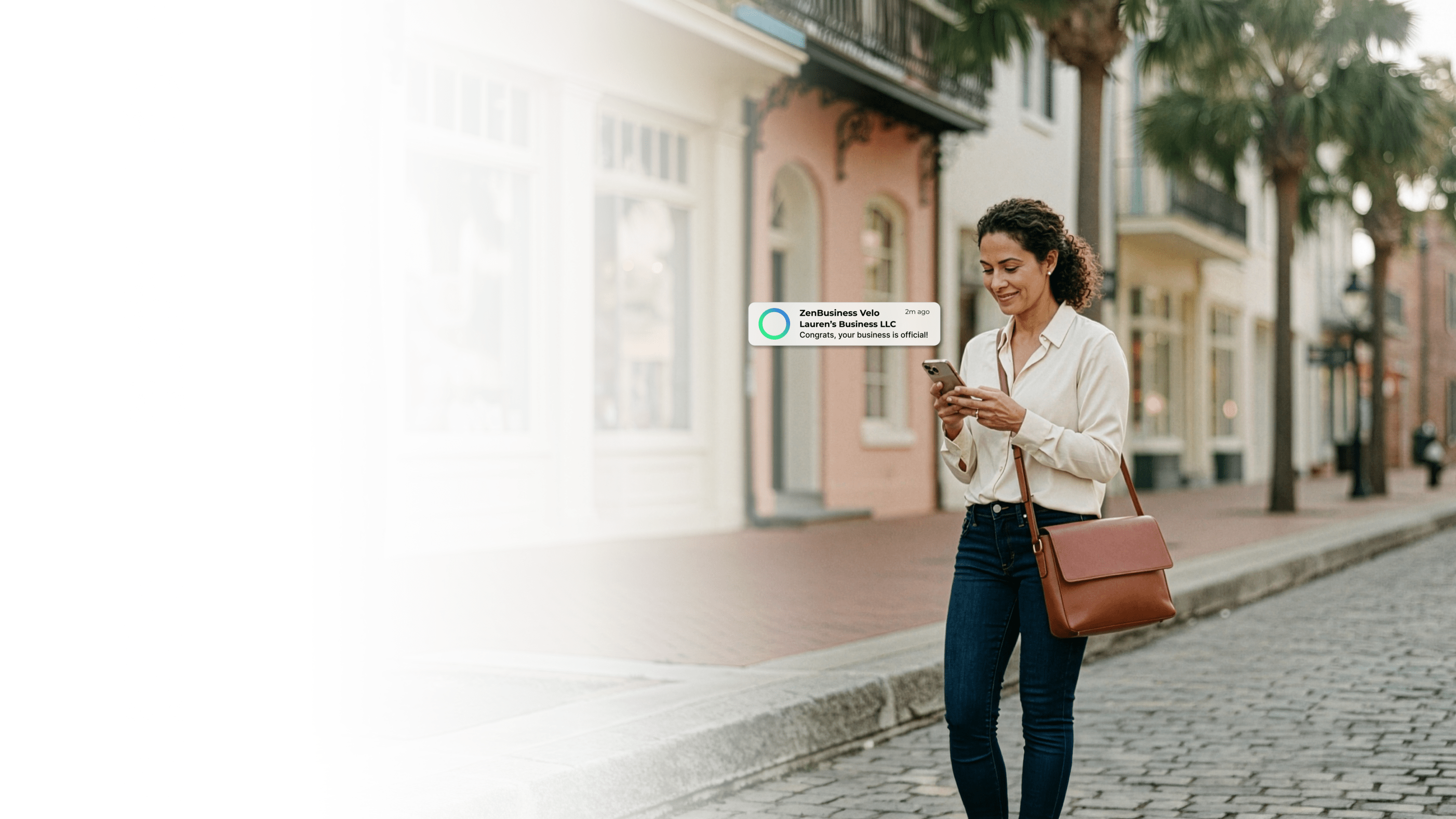 Female entrepreneur walking along a historic Charleston South Carolina street with colorful storefronts after her ZenBusiness Velo notification confirmed her LLC is approved